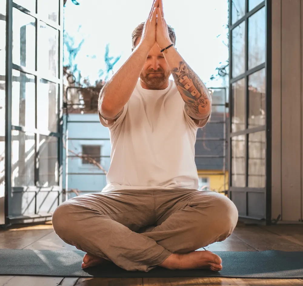 Marc Zimmermann im Breathwork Studio Hamburg, die Hände vor der Brust zusammengelegt